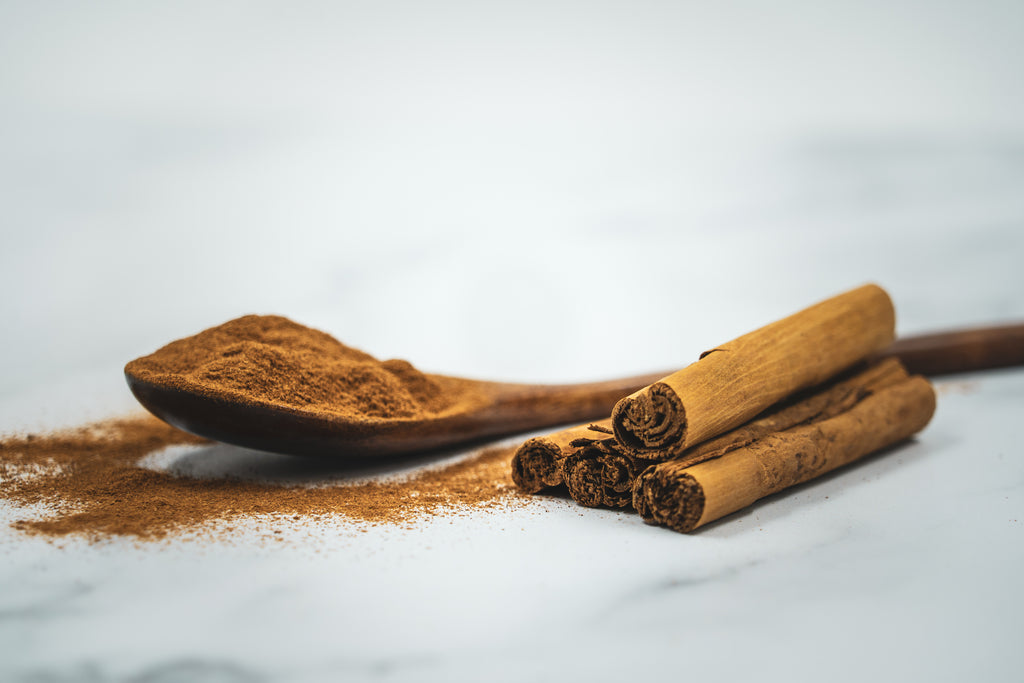 High-resolution ground cinnamon powder with cinnamon bark, accurately representing Spice Czar Ground Cinnamon. Photo by Formulate Health via Wikimedia Commons, CC BY 2.0.