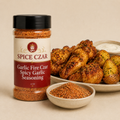 Garlic Fire Czar Spicy Garlic Seasoning in labeled 4 oz shaker with loose seasoning, wings, and potatoes