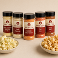 Popcorn Czar Flavor Flight: five 2 oz shakers (White Cheddar Jalapeño, Garlic Parmesan, Buffalo Blue Cheese, Chili Lime, Smoky BBQ) with seasoned popcorn