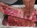 Dry spice rub being applied to pork ribs, representing Spice Czar All American Dry Rub. Photo by Daryn Nakhuda via Wikimedia Commons, CC BY 2.0.
