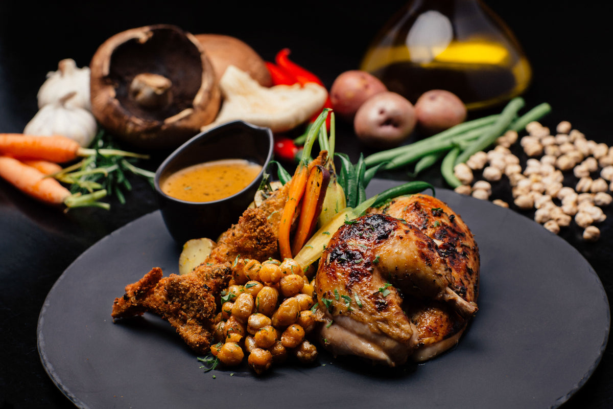Serving suggestion for Butcher's Best Chicken Rub: browned spiced chicken with roasted vegetables and seasoned chickpeas. Photo by Mahmoud Salem/Pexels; not a photograph of the dry blend or a verified cook using this product.