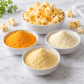 Ingredient and serving illustration: cheddar, white cheddar and Parmesan-style cheese powders in three bowls with seasoned popcorn. Packaging not shown.