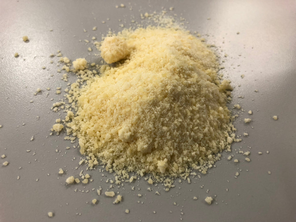 Close-up of finely grated Parmesan cheese showing the pale dairy-forward base of Spice Czar Garlic Parmesan Seasoning. Photo by Famartin via Wikimedia Commons, CC BY-SA 4.0.