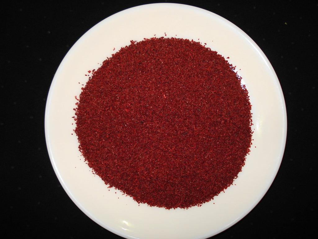 High-resolution deep ruby ground sumac powder, accurately representing Spice Czar Ground Sumac. Public-domain photo by Miansari66 via Wikimedia Commons.