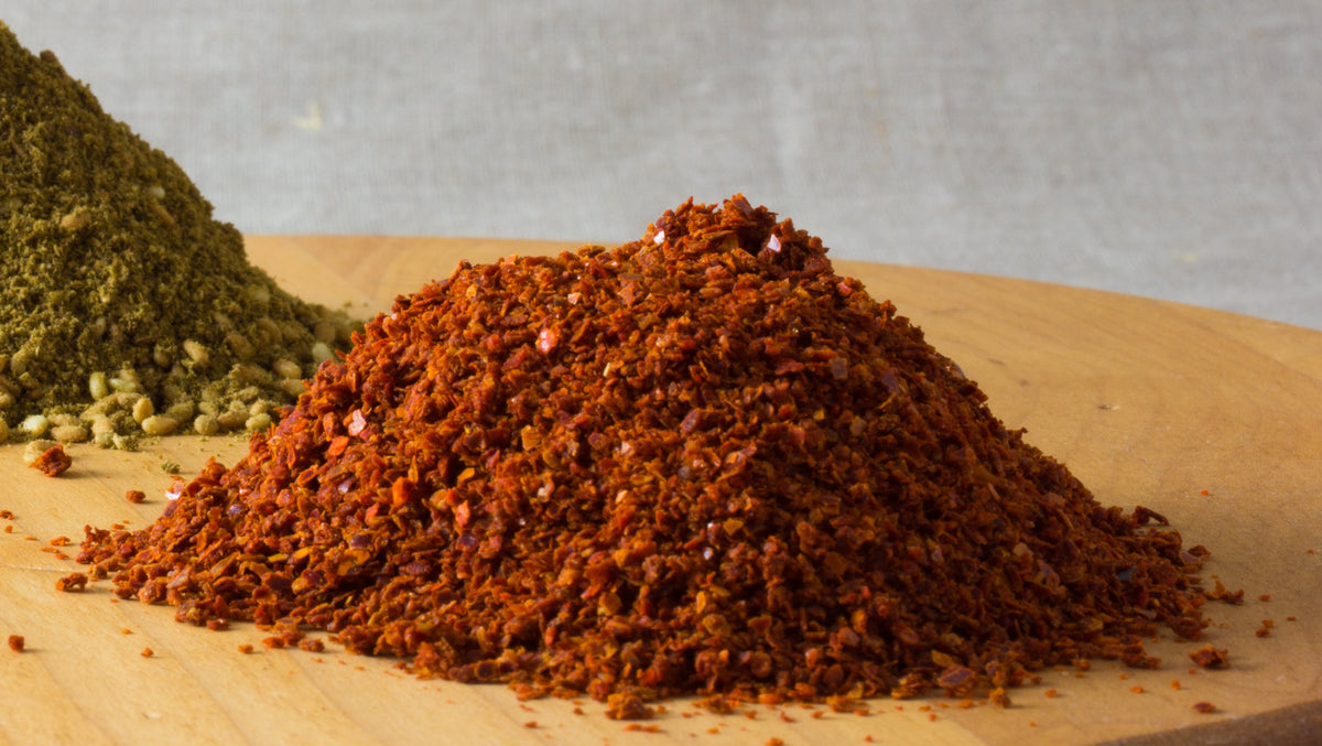 Aleppo pepper flakes showing the dominant red-orange texture of Spice Czar Honey Aleppo Pepper Seasoning. Photo by Veganbaking.net via Wikimedia Commons, CC BY-SA 2.0.