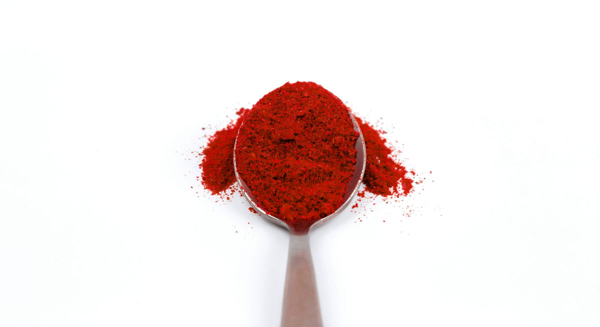 Deep red chile powder representing the ancho-paprika dominant color of Spice Czar Mexican Chorizo Seasoning. Photo by Volodymyr Hryshchenko via Unsplash, used under the Unsplash License.
