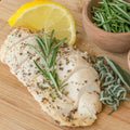 Serving suggestion for Poultry Seasoning: sliced chicken with visible dried herb flecks, rosemary, sage and lemon. Photo by Loren Castillo/Pexels; not a photograph of the dry blend or a verified cook using this product.