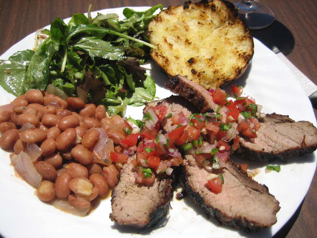 Santa Maria-style barbecue plate with tri-tip, salsa, beans, salad and garlic bread, a serving idea for Spice Czar Santa Maria Seasoning. Photo by Eugene Kim via Wikimedia Commons, CC BY 2.0.
