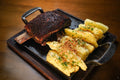 Serving suggestion for Smoky Honey BBQ Rub: beef ribs with a clearly textured dark spice crust beside seasoned potatoes. Photo by Geancarlo Peruzzolo/Pexels; not a photograph of the dry blend or a verified cook using this product.