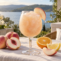 Serving suggestion: Peach Citrus Sangria slushy with complementary fruit and a lake or moored-boat setting.